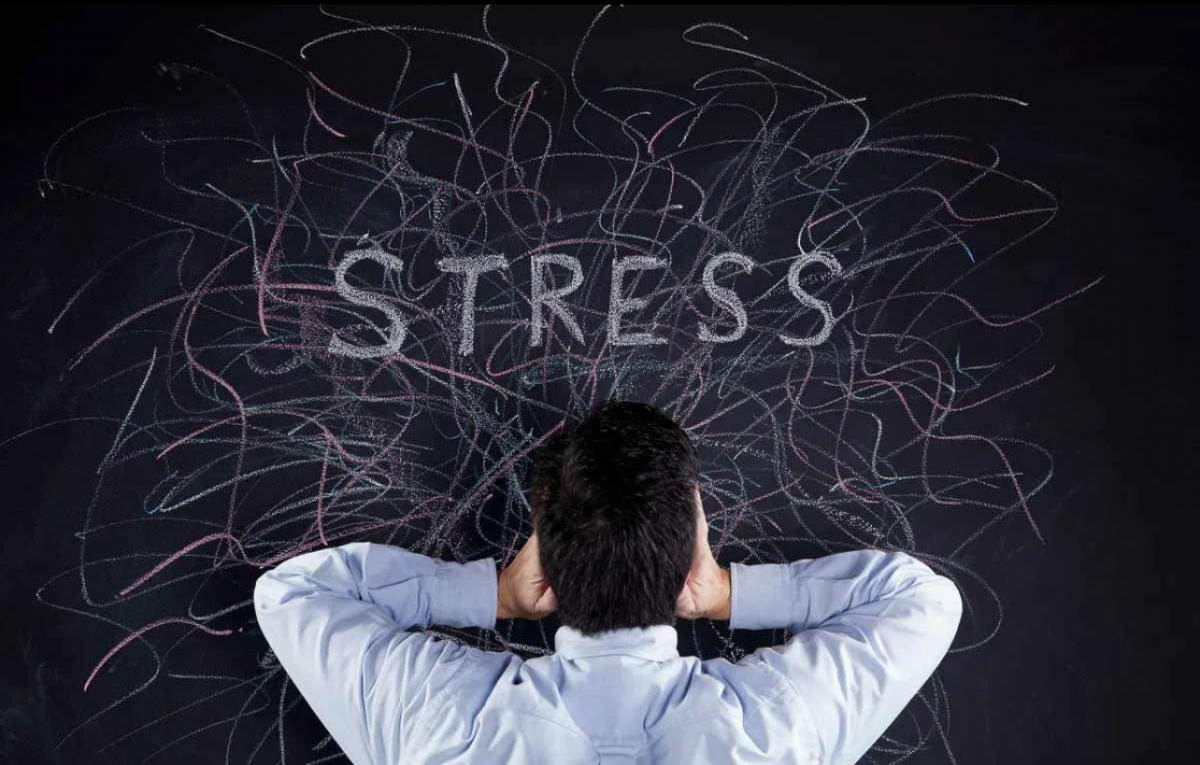A man, seen from behind, covers his ears, surrounded by chaotic, colorful lines and the word "STRESS" prominently displayed.