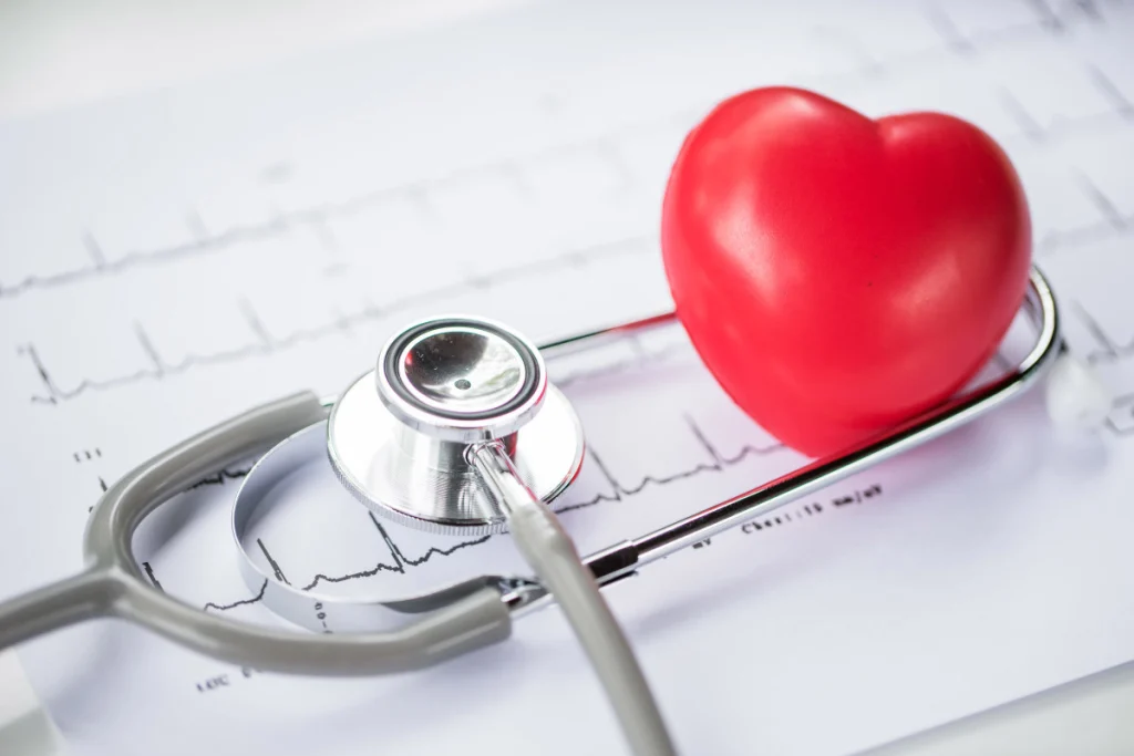 A stethoscope rests on an ECG chart, with a vibrant red heart symbolizing health and wellness in the medical field. stress test,